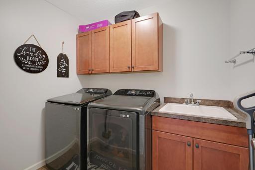 Upper level also features a laundry room with cabinet storage and utility sink.