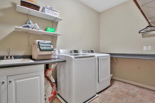 Main floor laundry with deep sink cabinet, washer with over flow tray.