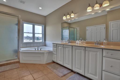 Spacious private primary bath with ceramic floor, shower and corner jacuzzi tub as well as double sinks. Boasts 2nd walk in closet as well as two linen closets.
