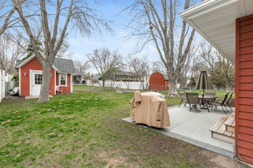 Patio space, fenced yard, and back playhouse.