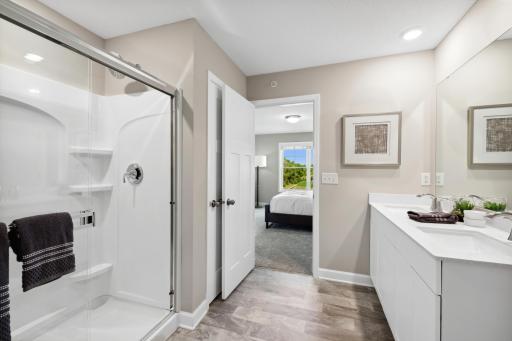 (Photo of decorated model, actual home's finishes may vary slightly) Adjacent to the owner's suite, this private bath is truly a retreat featuring a double-vanity!