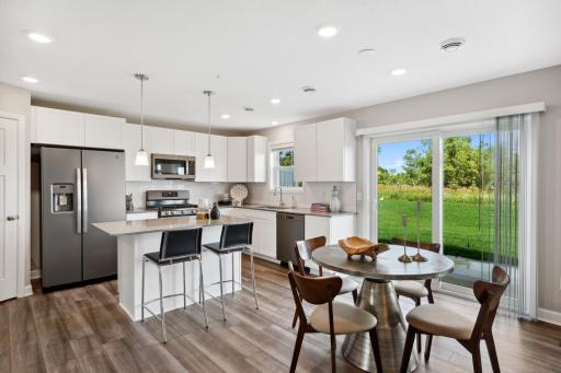 (Photo of decorated model, actual home's finishes may vary slightly) Enjoy plenty of seating at the kitchen island and dining area adjacent to the kitchen. Perfect for entertaining or having a family meal together.