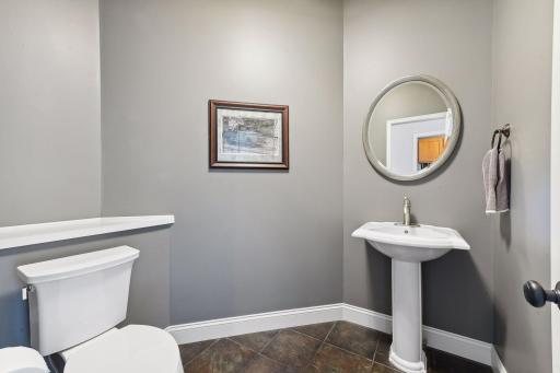 The main level Powder Room has been updated with a new Koehler toilet and features tiled flooring.