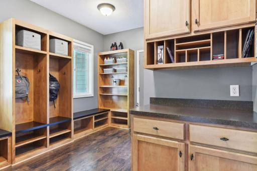 The ultimate Mud Room! Ideal for our Minnesota lifestyles, this large space offers extensive built-ins including four lockers with cubbies and shoe shelving, boot-benches, a handy "Drop Station" and a walk-in closet with custom shelving.