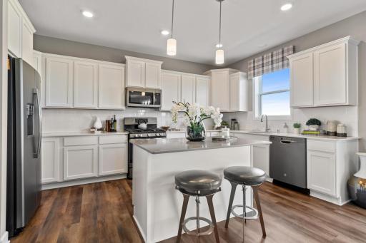 (Photo is of a model, homes finishes vary) Welcome to the Springfield! This spacious kitchen features a large center island, quartz countertops, LVP floors, stainless appliances and more.