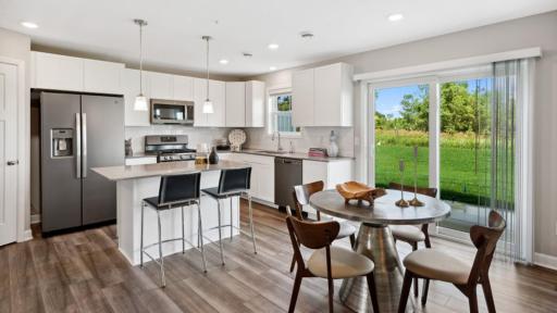 (Photo of a decorated model, actual homes finishes will vary) Situated between the kitchen and Great Room is a dining area, ready for meals of all occasions.