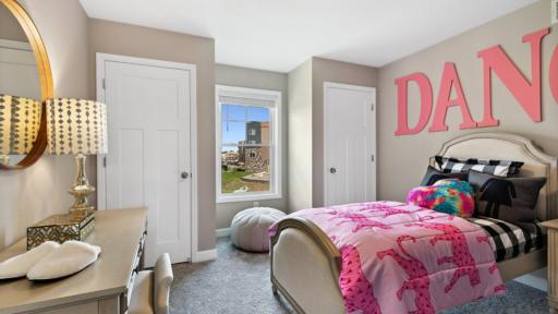 (Photo of a decorated model, actual homes finishes will vary) This secondary bedroom on the second floor provides two closets, making it an ideal space for siblings to share.