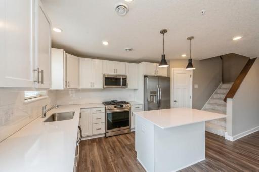 (Photo of a similar home, actual homes finishes will vary) Sleek cabinetry and elegant vinyl plan flooring contribute to the kitchen's polished look.