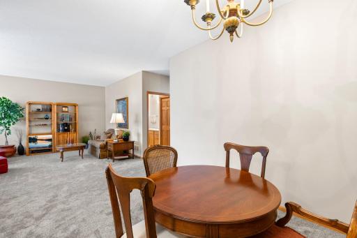 Complete with a charming chandelier and a window overlooking the well-appointed kitchen.