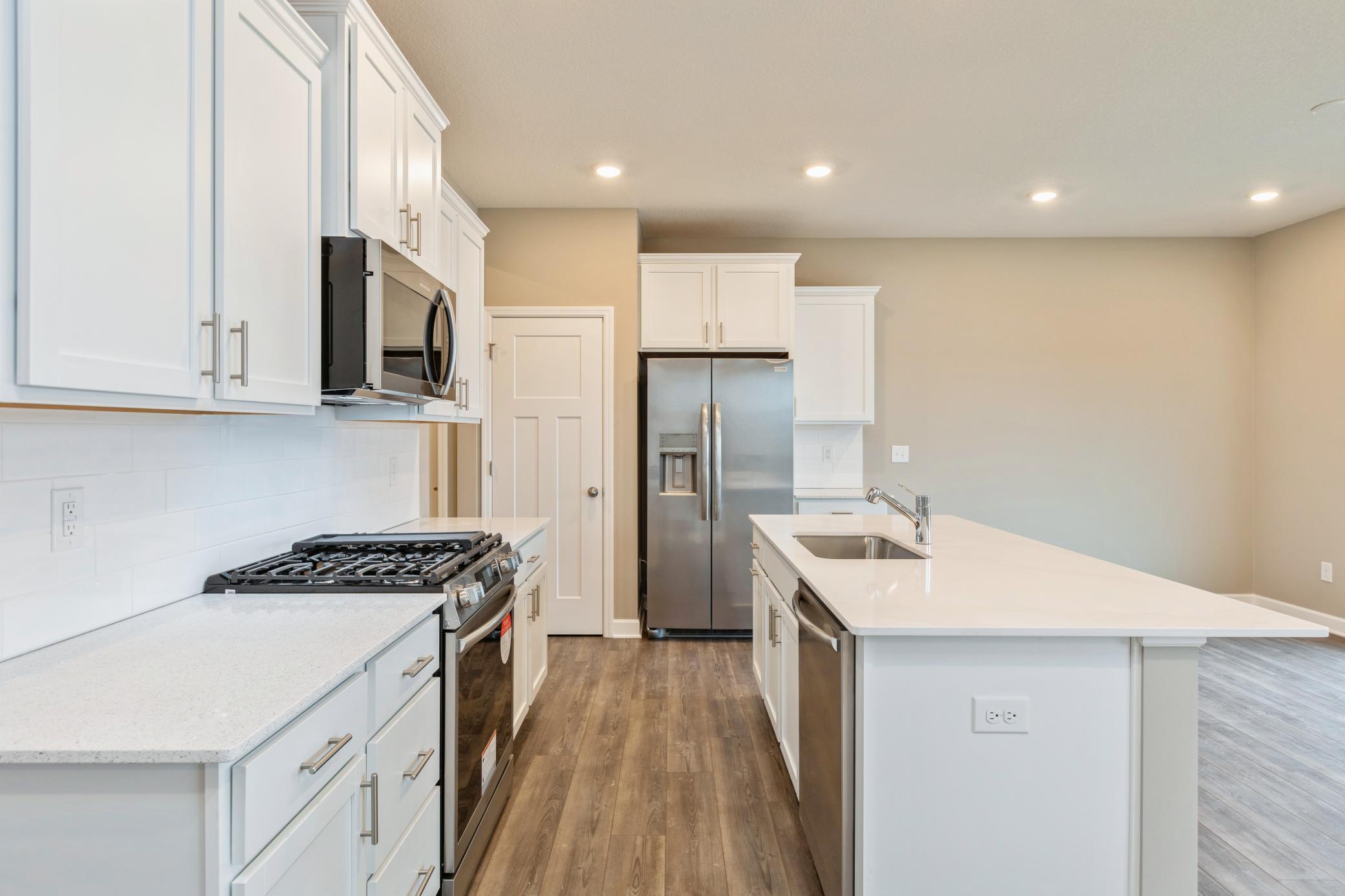 (Photo of similar home, finishes will vary) Welcome to the Glacier! This spacious kitchen includes a large center island, quartz countertops, recessed lighting, LVP wood floors, stainless appliances and more.
