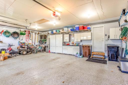 This spacious finished and insulated garage doubles as a functional workspace, featuring extensive storage solutions and a neat arrangement that maximizes the utility and versatility of the space.