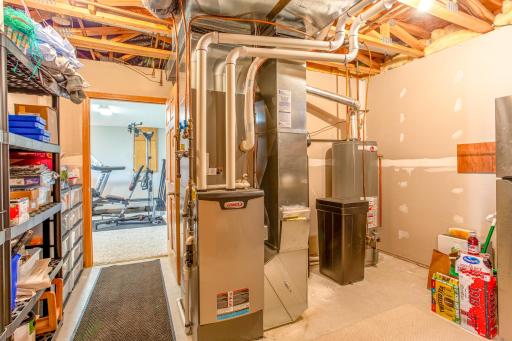 A practical utility room with essential equipment for home maintenance, including a furnace and storage shelves, meticulously organized to maximize space and efficiency.