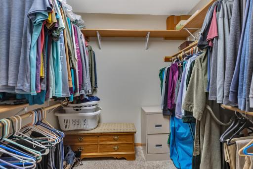 Here is the primary bedroom’s walk-in closet with shelving and clothes hanging bars. It also has a pocket door which leaves you with more bedroom floor space.