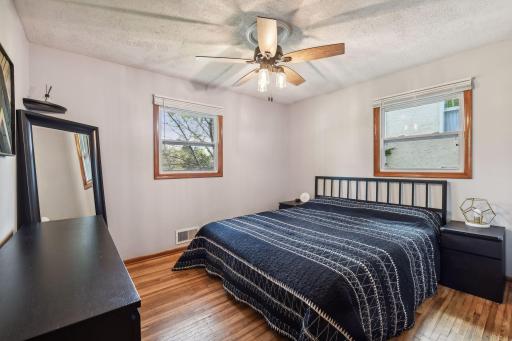 Primary bedroom with hardwood floors and ceiling fans