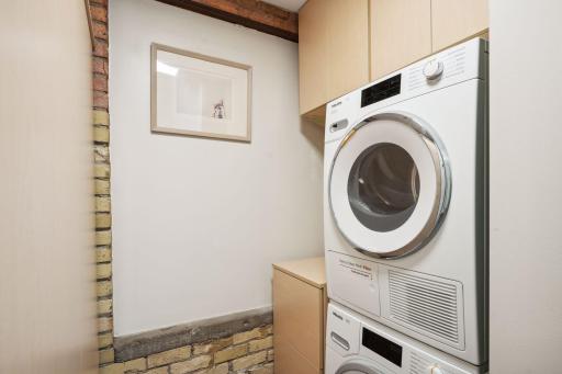 Ample custom linen storage and stackable washer and dryer