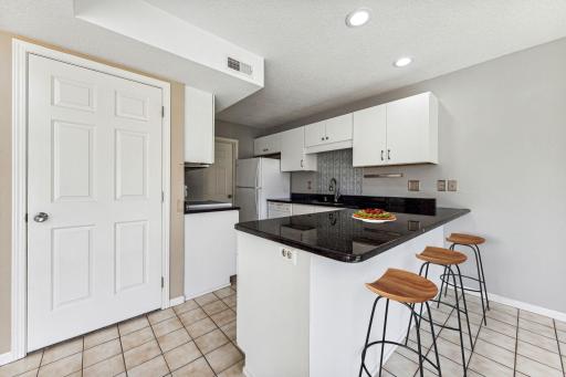 Kitchen features beautifully refaced cabinets, granite counter tops, and breakfast bar.