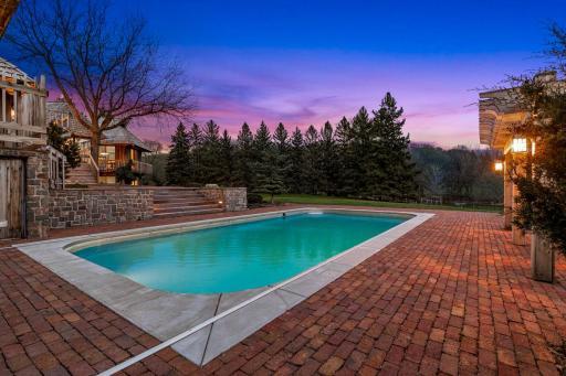 The in-ground pool is surrounded with paver patios and offers stunning views of the sprawling property.