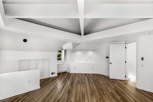 The primary bedroom offers custom built-ins, lighting, ceiling design and charming details throughout.