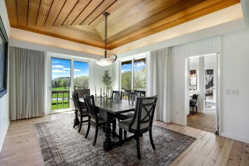 The spacious dining room features a beautiful custom plank ceiling.
