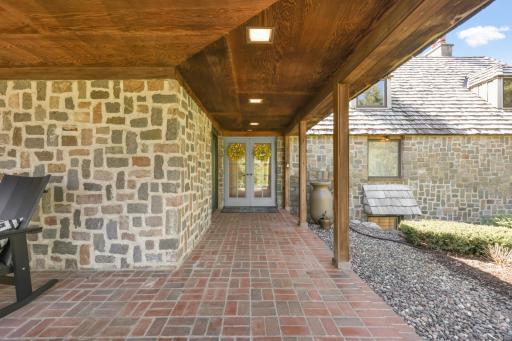 The home is surrounded by charming landscaping and paver patios.