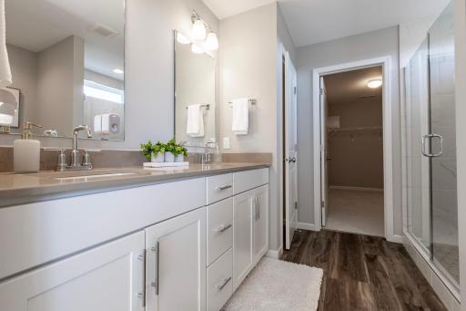 Connected to the primary suite is this bathroom, which includes a double-vanity, stand-in shower and oversized walk-in closet.