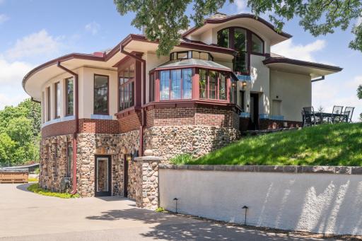 The exterior of the house's lower level is face with smooth boulders.