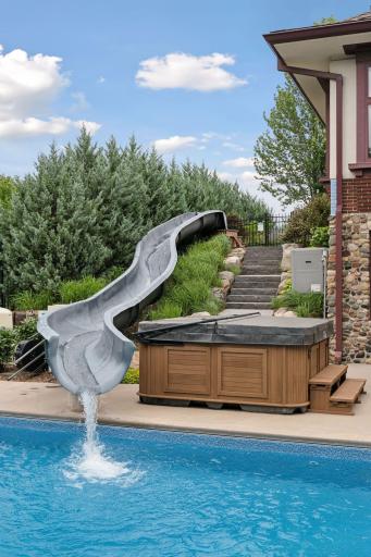 Granite steps lead to the 49.2 ft. resort quality waterslide that features 170 gallons per minute flow rate. Saltwater Arctic Spa Tundra 8 person hot tub, complete with Spa Boy automatic chemical management.