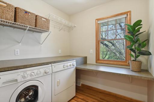 A rare find - upper level laundry room with great folding counter space and a window with treetop views