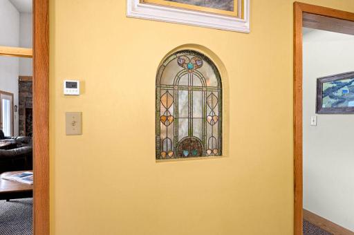 This built-in antique 130 year old stained glass window sits between the kitchen and the great room and adds a charming effect.