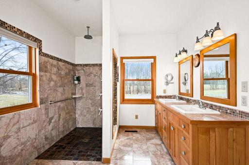 Walk-in shower with multiple shower heads, slate tile floor and marble walls. (Everything in this master is handicap accessible).