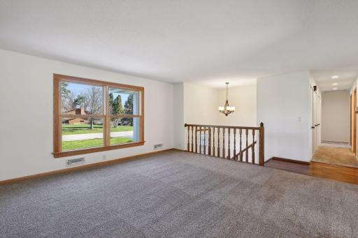 The light-filled living room provides ample space for entertaining family and friends. Recent updates include fresh paint in 2024, new windows installed in 2021, and brand-new carpeting from 2020.