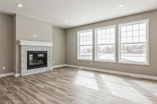 (Photo of a similar home, actual homes finishes will vary) Centered gas fireplace in great room with stunning, private nature views out the back windows!