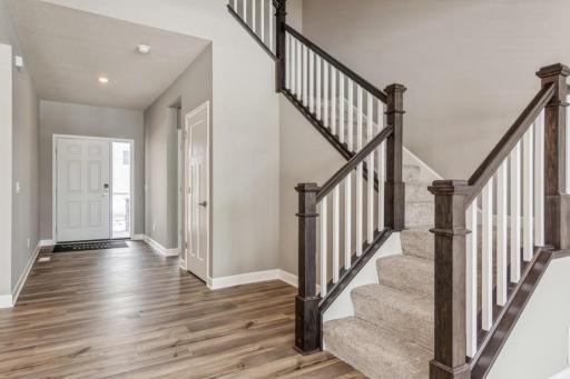 (Photo of a similar home, actual homes finishes will vary) Open main entrance/foyer with grand staircase that leads to the upper level four bedrooms, three bathrooms, loft area and a spacious laundry room.