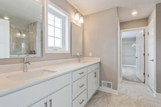 (Photo of a similar home, actual homes finishes will vary) An extension of the primary suite, this private and spa-like bath contains a double-vanity, a walk in shower with 2 shower heads and 2nd walk-in closet.