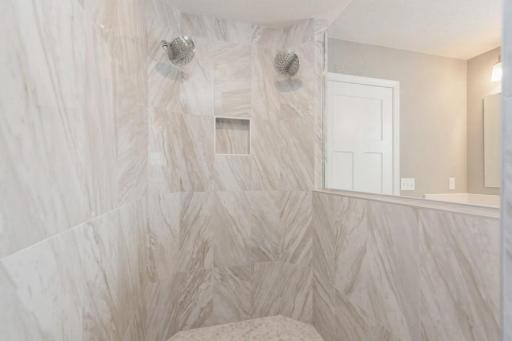 (Photo of a similar home, actual homes finishes will vary) Primary suite walk-in tiled shower with dual shower heads!