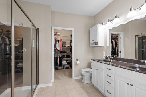 The ensuite primary bathroom is a spa-like haven with double sinks, large walk-in shower, and a spacious walk-in closet, ensuring both luxury and convenience.