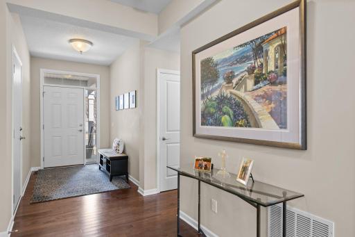 As you enter the front door, a welcoming foyer adorned with beautiful wood floors sets the tone for the entire residence. The elegance of these wood floors extends seamlessly into the kitchen, creating a cohesive and sophisticated look.