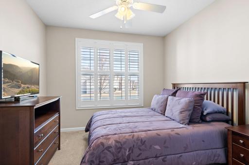 Bedroom 2 on the main floor features ceiling fan and front yard view