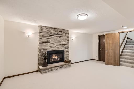 Lower level family room with new stacked-stone fireplace and gas insert in 2019. Updated lighting.