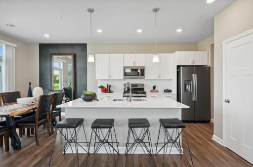 (Photo of decorated model, actual home's finishes will vary) Enjoy plenty of seating at the kitchen island and dining are adjacent to the kitchen. Perfect for entertaining or having a family meal together.