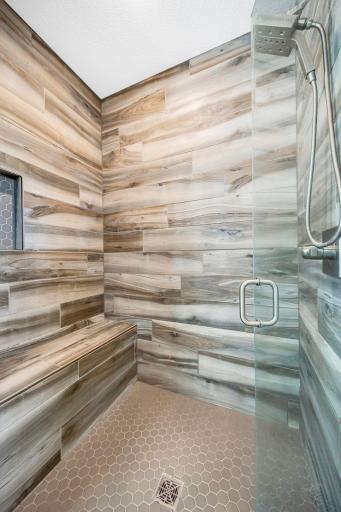 Fabulous custom tile shower with bench and gorgeous glass doors.