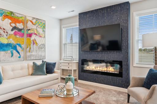 (Photo is of a decorated model, actual homes finishes will vary) The home comes with a stunning electric fireplace featuring a heat on/off feature & multiple color settings, 2 large windows & blinds.