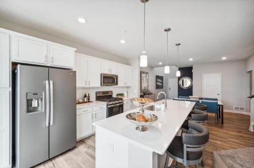 (Photo is of a decorated model, actual homes finishes will vary) The kitchen comes complete with the slate - finish appliances- including a gas range, microwave, fridge & dishwasher.