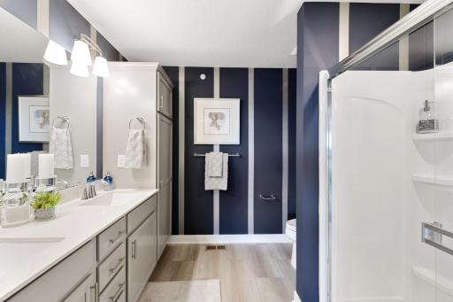 (Photo is of a decorated model, actual homes finishes will vary) Be impressed with the owner's suite private bath - a large walk in shower, hidden toilet, a linen cabinet and a double sink vanity w/quartz countertops!