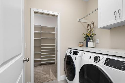 Laundry with upper cabinets and pole to hang clothes.