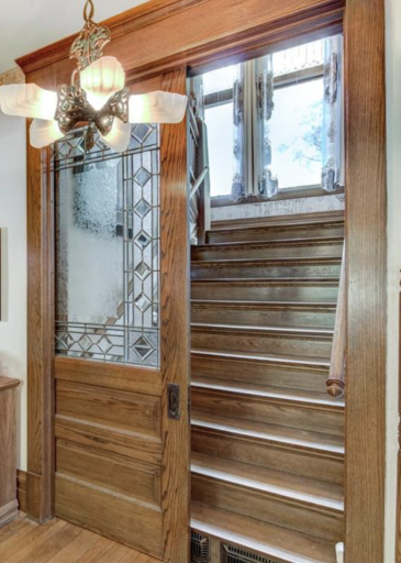 Stunning leaded glass pocket door leading up the grand staircase.png