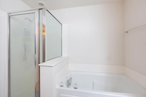 Upper level bathroom with tub and shower. Access to primary bedroom and loft.