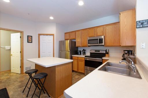Large kitchen with utility room and powder room access. Kitchen island can accommodate two chairs with maximized seating.