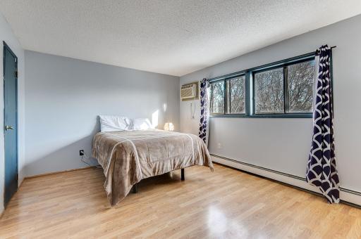 The bedroom has a wide windowscape to let in plenty of light, and the steely blue colors continue to tie the unit together.