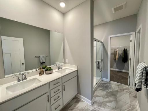 Photo of similar home, colors and finishes will vary. The primary spa like sanctuary comes complete with a large double-vanity including quartz countertops, shower with glass door and walk-in closet!